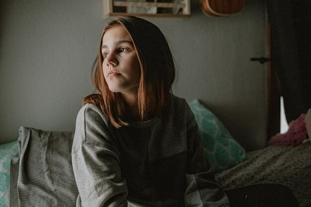 Preteen looking out window during lockdown