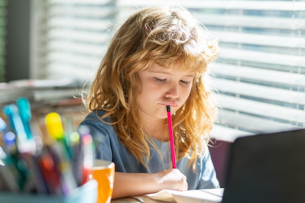 Preteen serious schoolboy doing her homework at home Child study Education and learning for kids Cute little boy doing homework in classroom