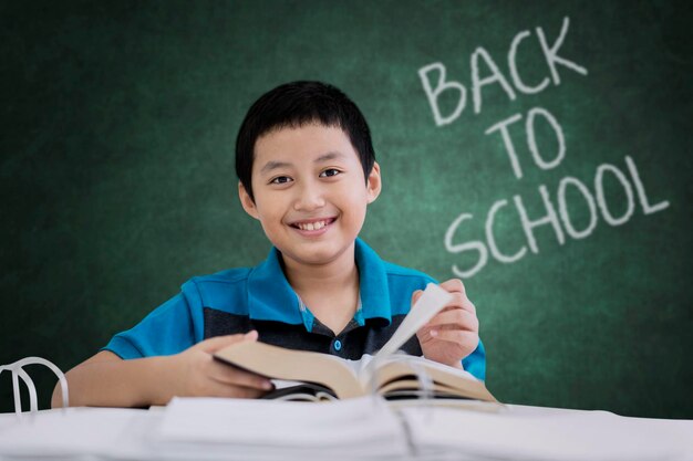 Preteen student reading a book in the classroom