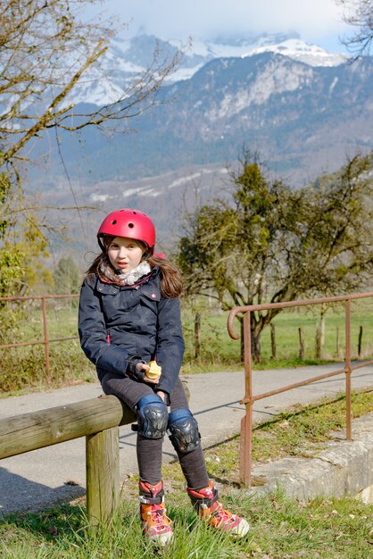 Preteen with roller skate helmet, eat an apple