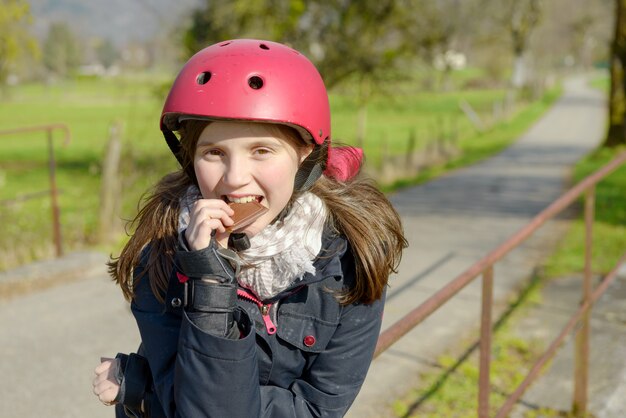 Preteen with roller skate helmet, eat a cake