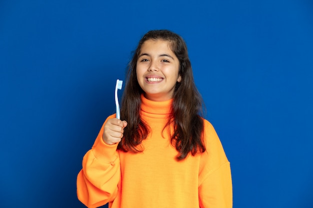 Preteenmeisje met het gele gesturing van Jersey over blauwe muur