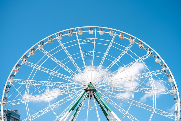 Pretpark en reuzenrad tegen de blauwe lucht