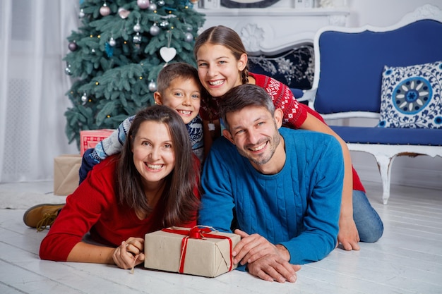 Prettige kerstdagen en fijne feestdagen. Mooie familie van vier plezier in kerstinterieur.