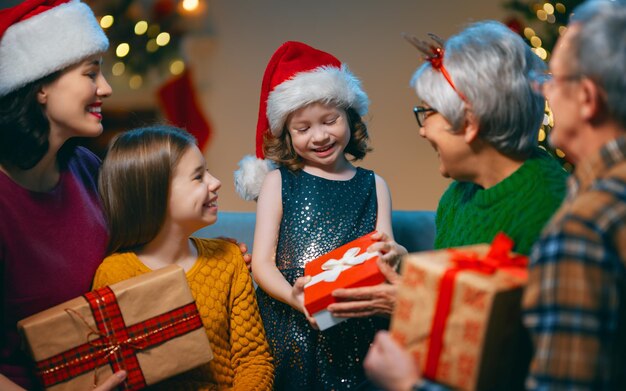 Prettige kerstdagen en fijne feestdagen oma opa moeder en kinderen wisselen geschenken uit