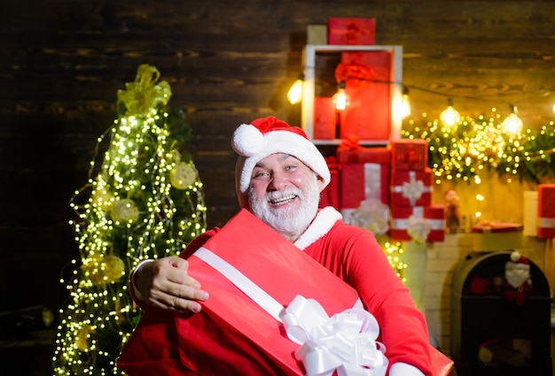 Prettige kerstdagen en gelukkig nieuwjaar bebaarde man in kerstkostuum met bezorgservice voor kerstcadeaus