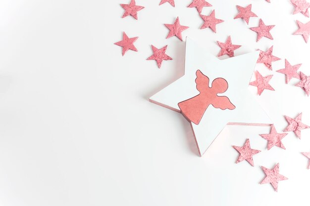 Prettige kerstdagen en gelukkig nieuwjaar concept Roze engel met sterren en kerstversiering geïsoleerd op wit Groet of uitnodiging Flat lay Kopieerruimte