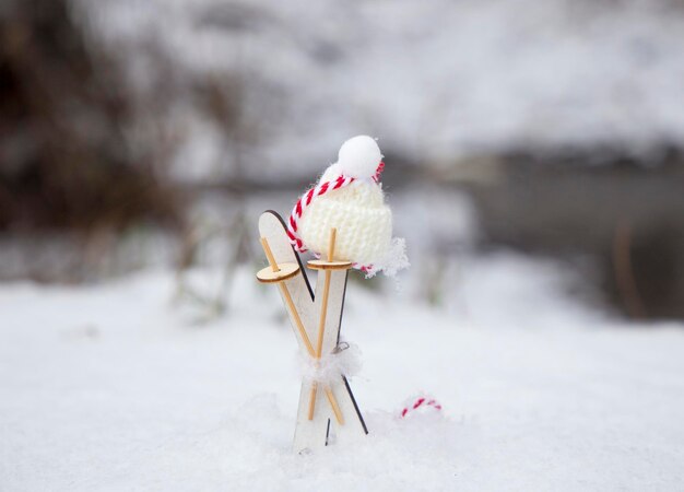 Prettige kerstdagen en gelukkig nieuwjaar kleine houten ski's en gebreide muts