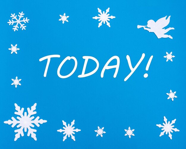 Foto prettige kerstdagen en gelukkig nieuwjaar tekst vandaag op een blauwe achtergrond met kerstsneeuwvlokken een witte engel