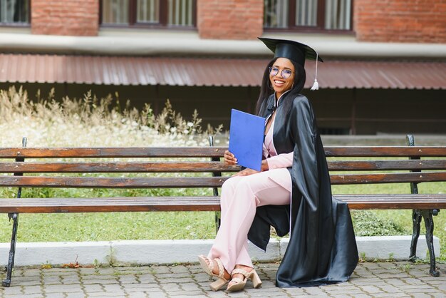 Pretty african american female graduate outside college building