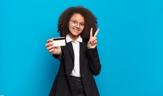 Pretty afro teenager business girl with a credit card. online shopping concept