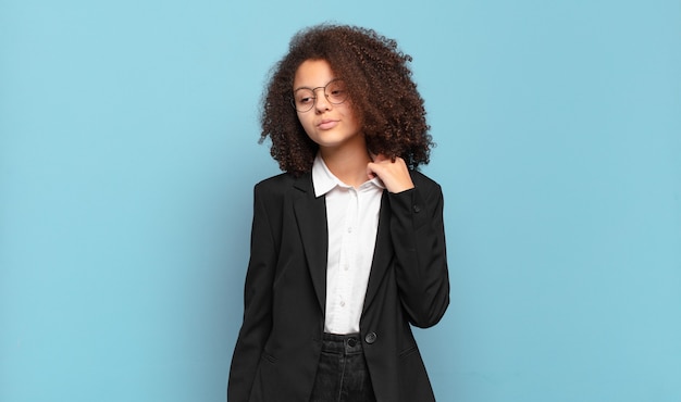 Pretty afro teenager feeling stressed, anxious, tired and frustrated, pulling shirt neck, looking frustrated with problem. humorous business concept