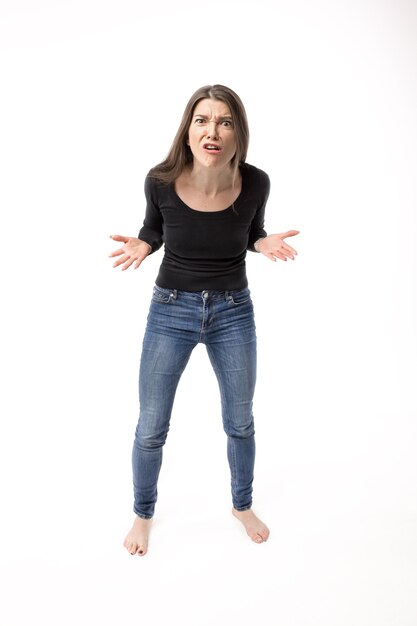 Pretty and aggressive young woman posing on the white isolated background.