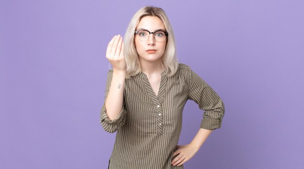 Pretty albino woman making capice or money gesture telling you to pay your debts