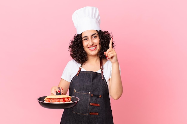 Foto cuoco unico del barbecue della donna araba graziosa che prepara gli hot dog