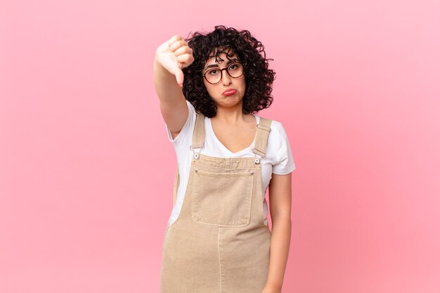 Pretty arab woman feeling cross,showing thumbs down