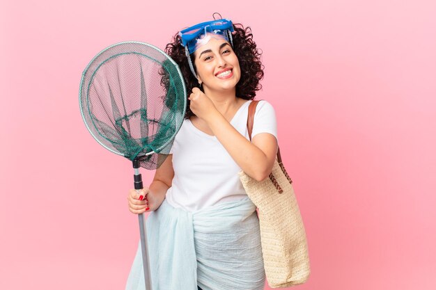 Pretty arab woman feeling happy and facing a challenge or celebrating with goggles. fisher concept