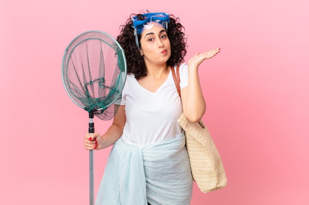 Pretty arab woman feeling puzzled and confused and doubting with goggles. fisher concept