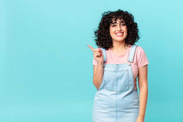 Pretty arab woman looking happy and pleasantly surprised