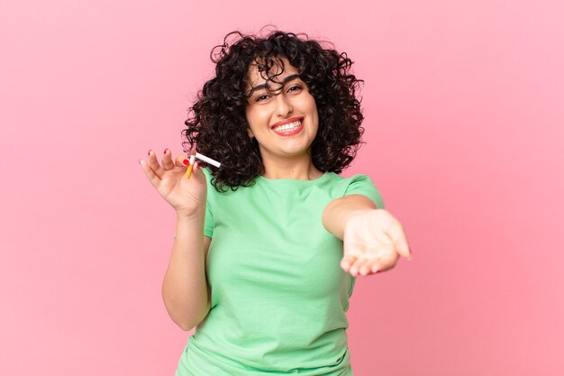 pretty arab woman smiling happily with friendly and  offering and showing a concept. no smoking concept