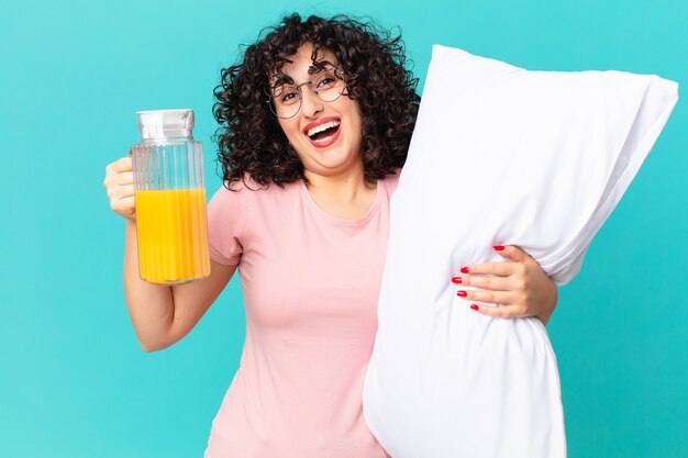 Pretty arab woman wearing pajamas and with a pillow.