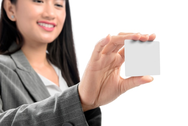 Довольно азиатская бизнес-леди показывая пустую визитную карточку на ее положении руки