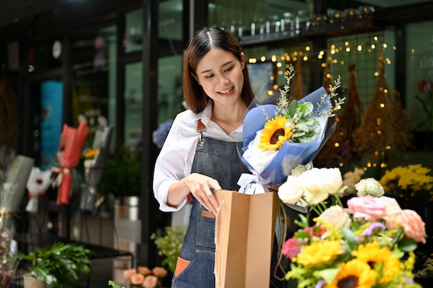 Pretty Asian female florist preparing a flower bouquet for a delivery order