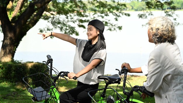 Photo pretty asian girl and grandmother walking with bicycle at park lifestyle family concept