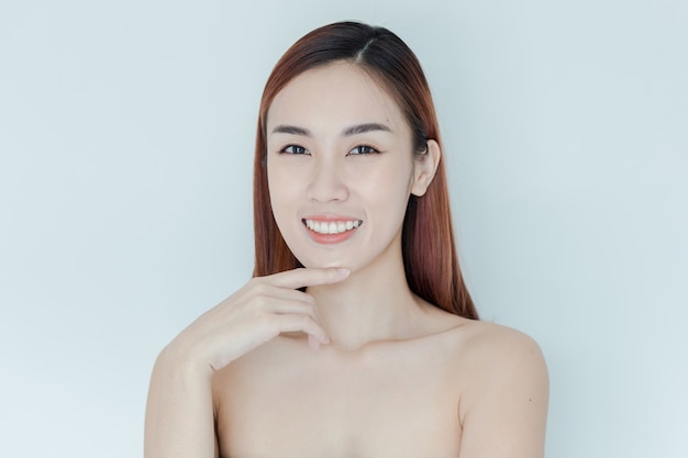 Ragazza piuttosto asiatica con grandi occhi e sopracciglia scure, con le spalle nude, bella donna che guarda l'obbiettivo e sorridente