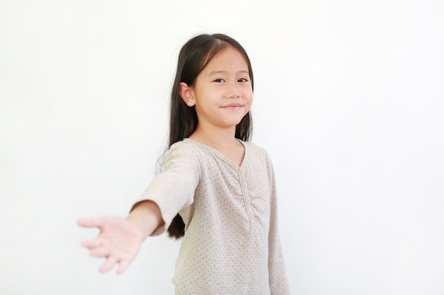 Pretty Asian little child girl welcome open hand gesture and smile isolated on white background.