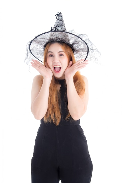 Foto donna abbastanza asiatica in cappello da portare della strega della tuta nera per il festival di halloween isolato sopra fondo bianco.