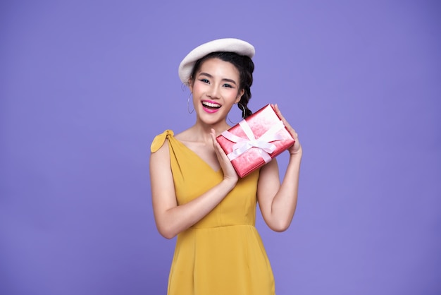 Pretty asian woman holding red presents with joyfully