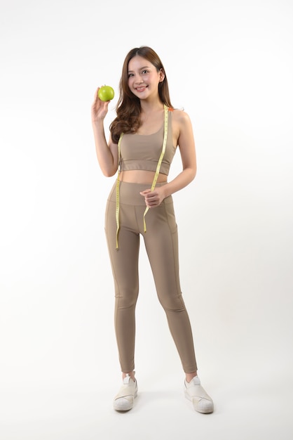 Pretty asian woman with apple and measure tape