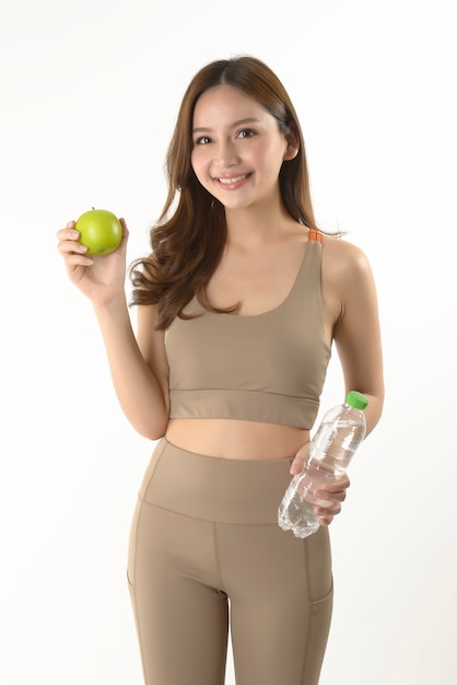 Довольно азиатская женщина с яблоком и водой