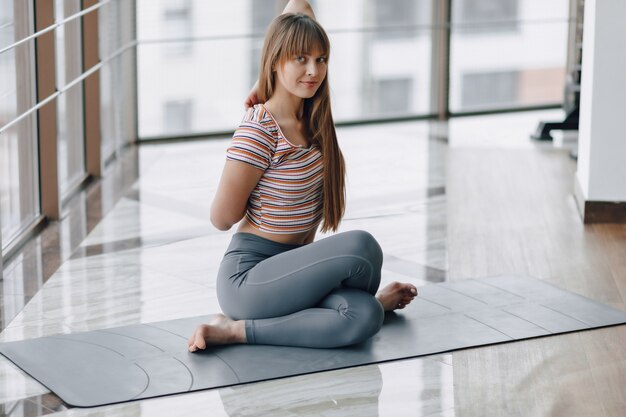 Photo pretty attractive girl doing yoga and relaxing in the bright room