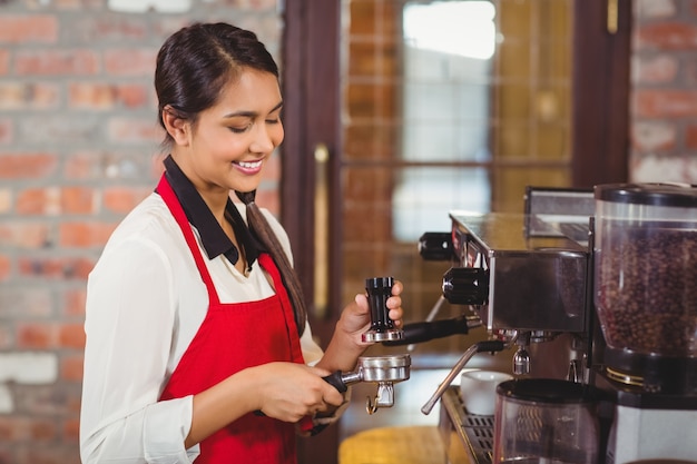 Grazioso barista che prepara una tazza di caffè