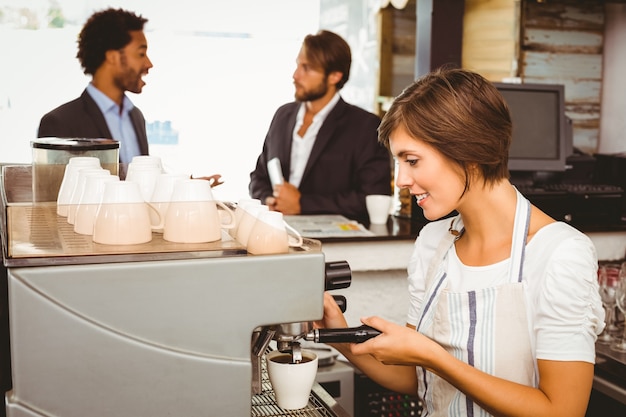 Bella barista che fa una tazza di caffè