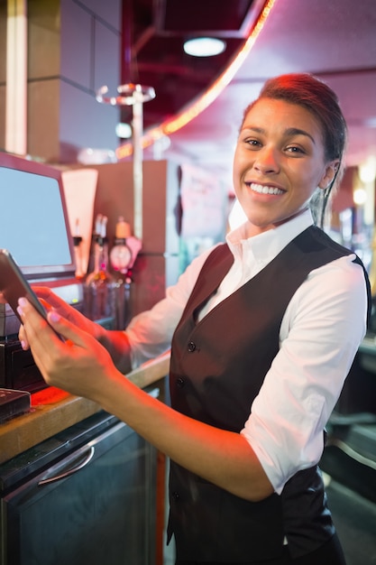 Pretty barmaid using touchscreen till 