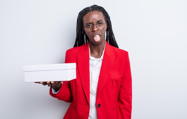 Pretty black woman feeling disgusted and irritated and tongue out. businesswoman with a white box