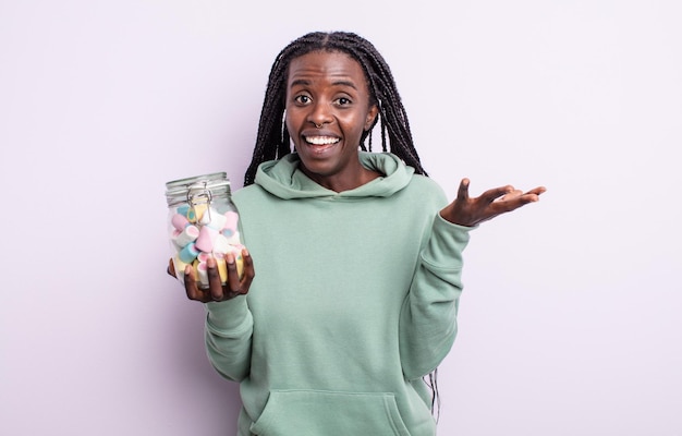 Pretty black woman feeling happy, surprised realizing a solution or idea. jelly candies concept