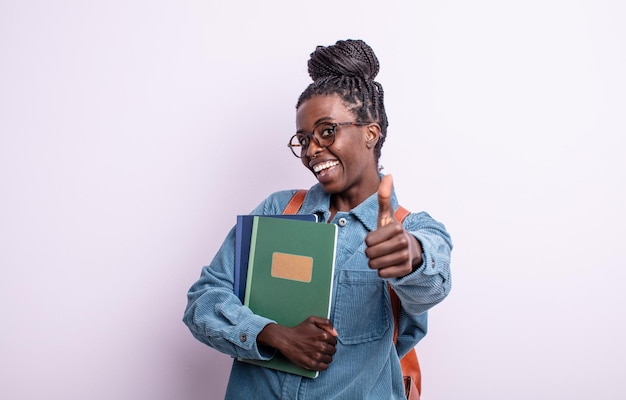 Pretty black woman feeling proud,smiling positively with thumbs up. student with books concept