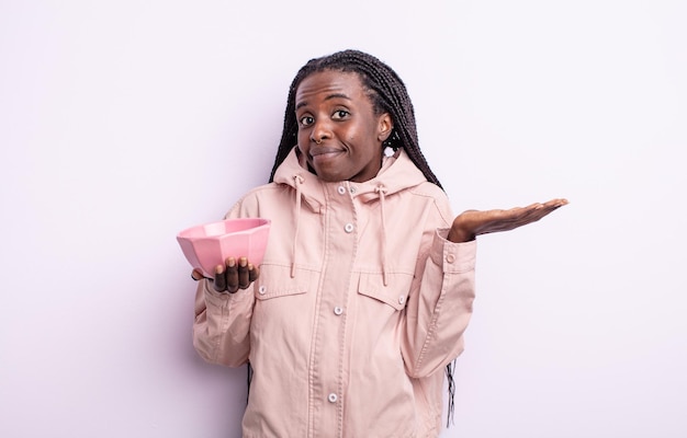 Pretty black woman feeling puzzled and confused and doubting. empty bowl concept