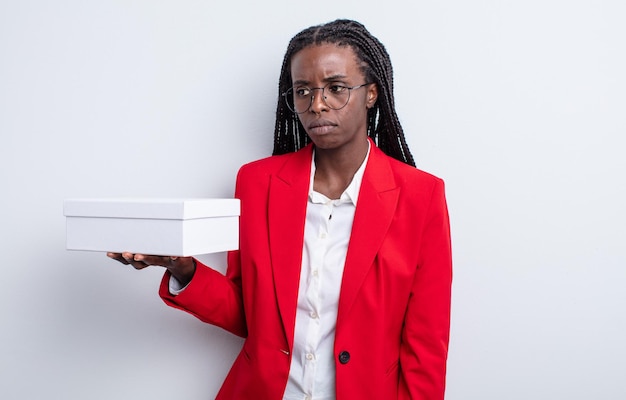 Pretty black woman feeling sad, upset or angry and looking to the side. businesswoman with a white box