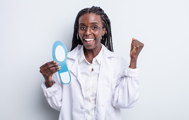 Pretty black woman feeling shocked,laughing and celebrating success. podiatrist concept