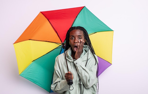 Pretty black woman feeling shocked and scared. umbrella concept