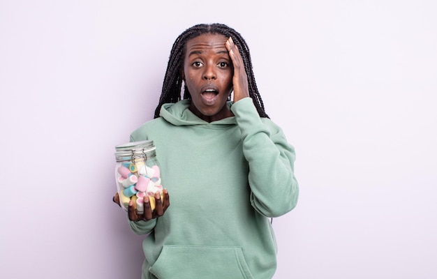 Pretty black woman looking happy, astonished and surprised. jelly candies concept