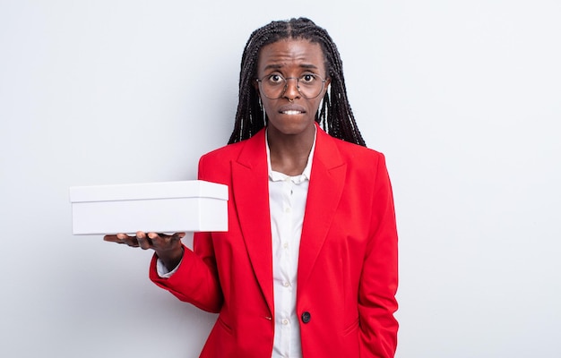 Pretty black woman looking puzzled and confused. businesswoman with a white box