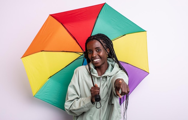 Pretty black woman pointing at camera choosing you. umbrella concept