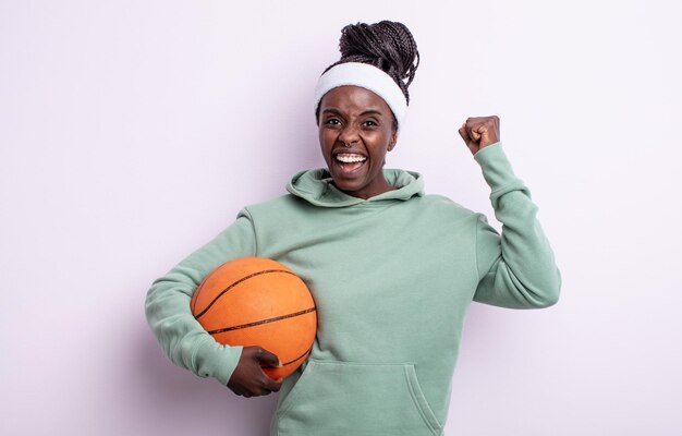 Pretty black woman shouting aggressively with an angry expression basketball concept