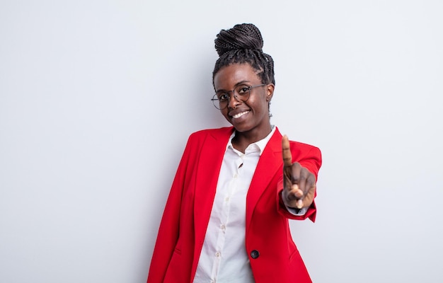 Pretty black woman smiling and looking friendly, showing number one. businesswoman concept